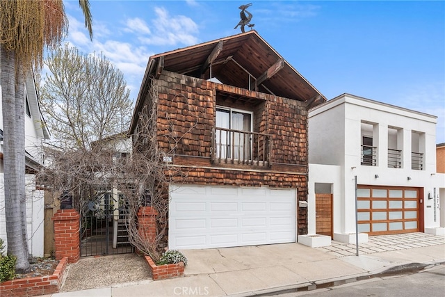 view of front of home featuring a garage, a balcony, driveway, and stucco siding