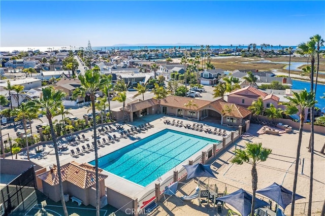 pool featuring a water view, fence, and a residential view
