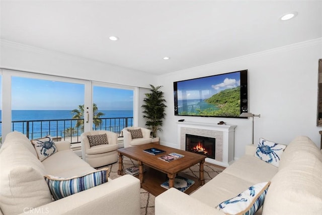 living area with a lit fireplace, ornamental molding, and recessed lighting