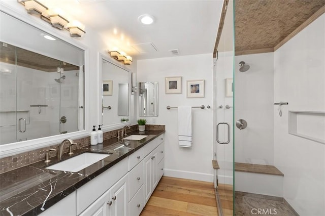 bathroom with a shower stall, a sink, and wood finished floors