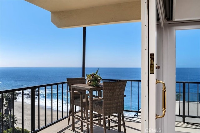 balcony with a water view and a beach view