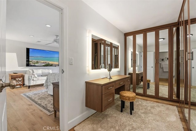 corridor with light wood-style floors and baseboards