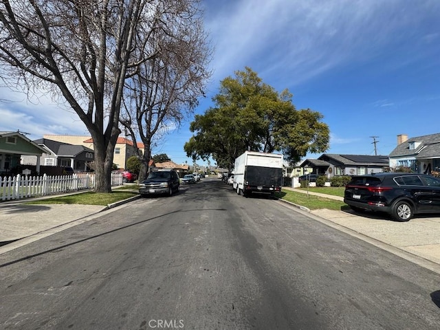 view of road with a residential view, curbs, and sidewalks