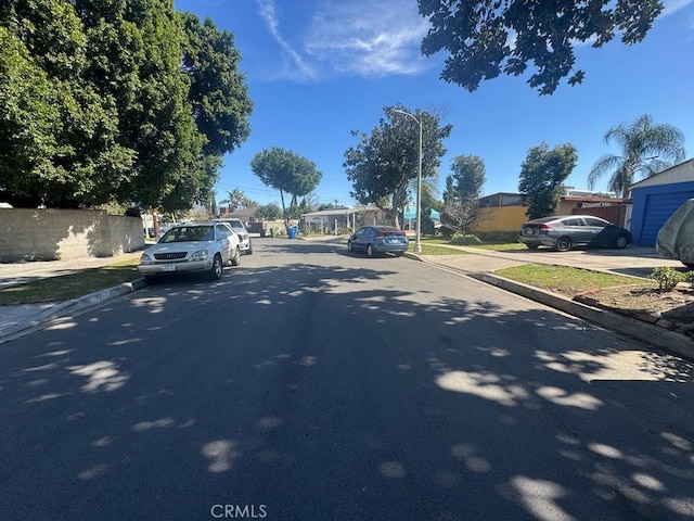 view of road with sidewalks, street lights, and curbs