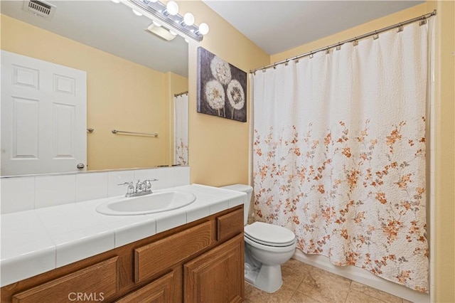 bathroom with toilet, tile patterned flooring, visible vents, and vanity