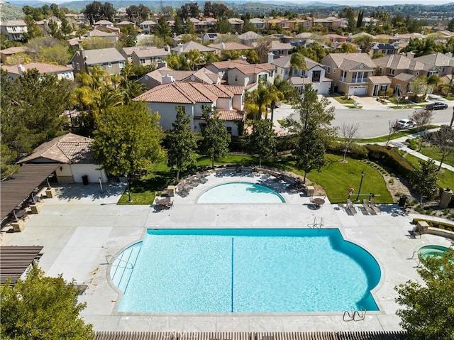 community pool with a residential view and a patio