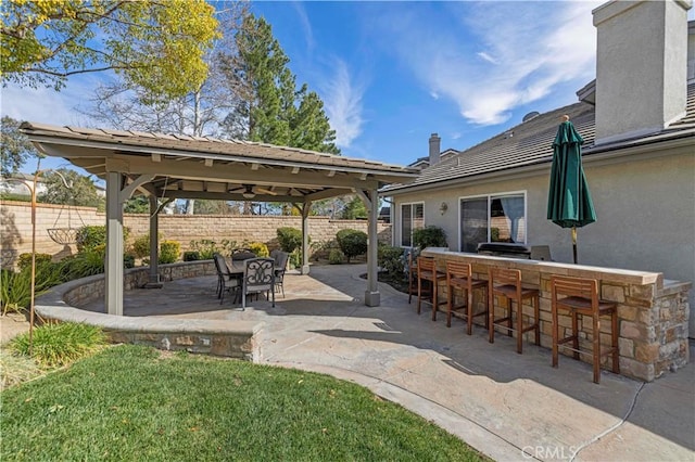 view of patio featuring fence and outdoor dry bar