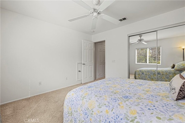 carpeted bedroom with a ceiling fan, a closet, and visible vents