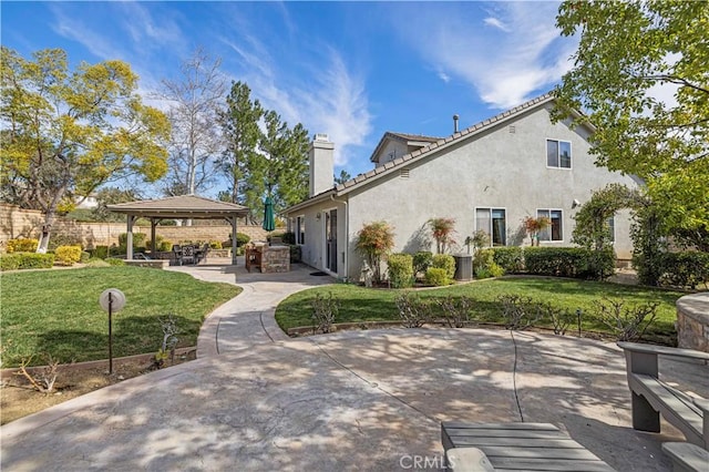 back of property with a patio, area for grilling, a gazebo, a lawn, and stucco siding