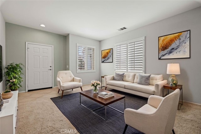 living area featuring light colored carpet, visible vents, baseboards, and recessed lighting