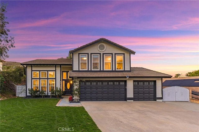 tri-level home with a gate, concrete driveway, and a yard