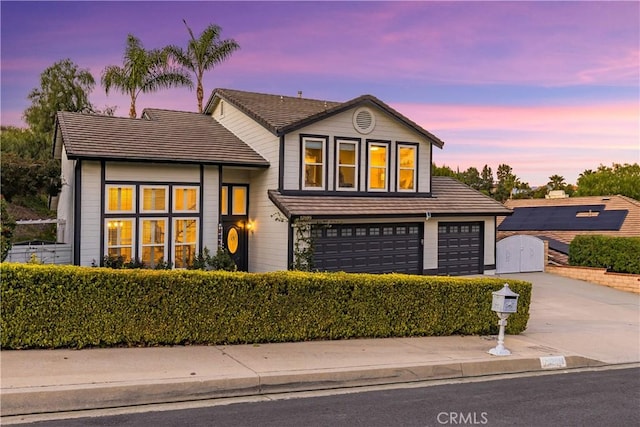 split level home featuring driveway, a garage, and a tiled roof