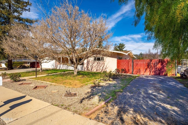 view of front of property featuring a front yard, fence, and stucco siding