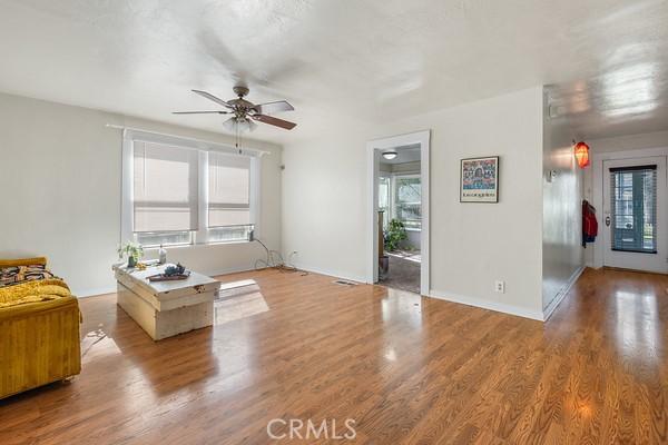 interior space featuring baseboards, a ceiling fan, and wood finished floors