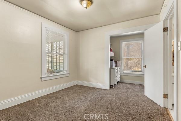 spare room featuring carpet flooring and baseboards