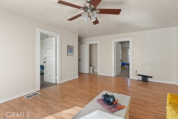 living room featuring visible vents, baseboards, and wood finished floors