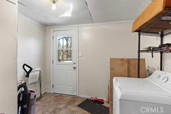 washroom with laundry area, baseboards, and washer / clothes dryer