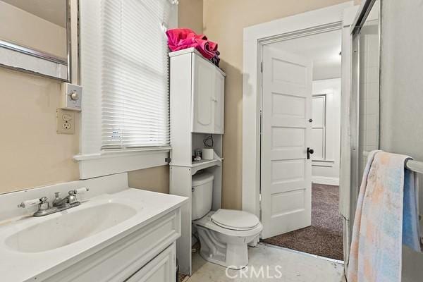 full bathroom with toilet, an enclosed shower, and vanity