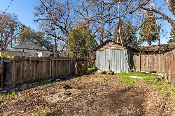 view of yard with an outbuilding, a fenced backyard, and a storage shed