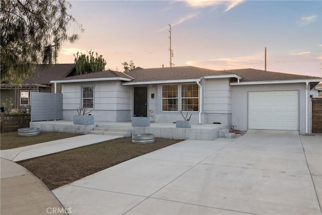 single story home with roof with shingles, driveway, and an attached garage