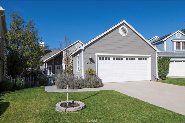 view of front of property featuring a garage, concrete driveway, and a front lawn