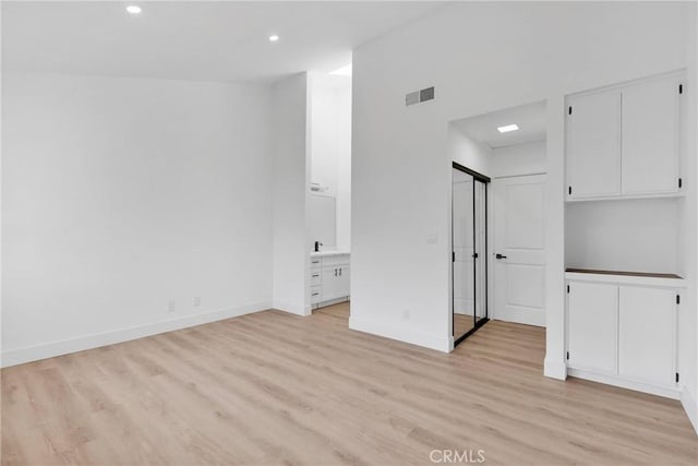 interior space featuring light wood-style floors, recessed lighting, visible vents, and baseboards