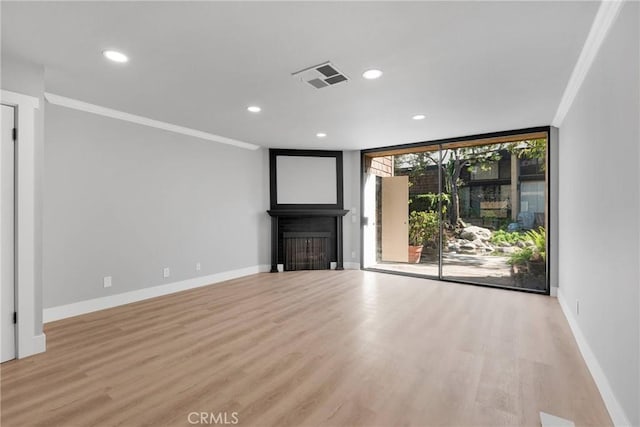 unfurnished living room with a fireplace, crown molding, visible vents, light wood-style flooring, and baseboards