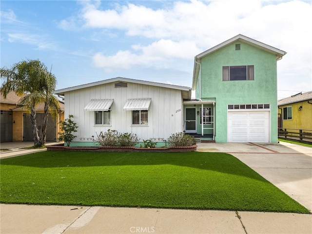 view of front of property with driveway, an attached garage, board and batten siding, and a front yard