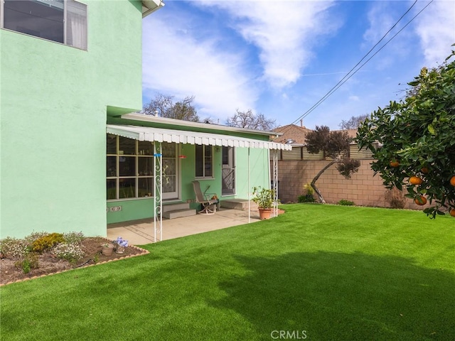 back of property featuring a yard, entry steps, a patio, and stucco siding