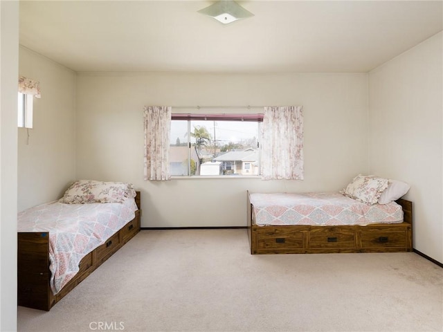 bedroom with light carpet, multiple windows, and baseboards