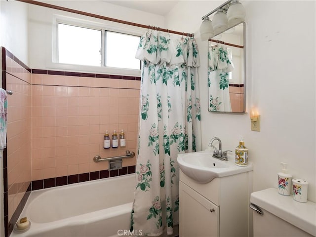 bathroom with toilet, shower / bathtub combination with curtain, and vanity