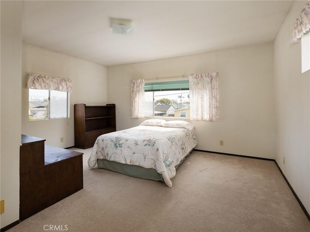 bedroom featuring light carpet and baseboards