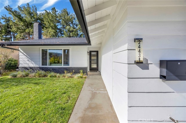 property entrance with a yard and a chimney