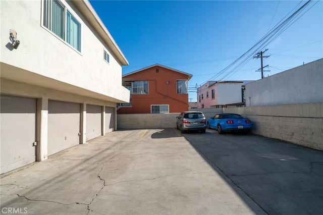 view of vehicle parking with fence