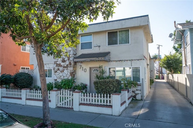 view of property with a fenced front yard and stucco siding