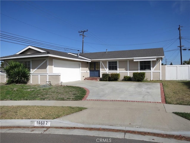 ranch-style house with a garage, fence, driveway, stucco siding, and a front lawn