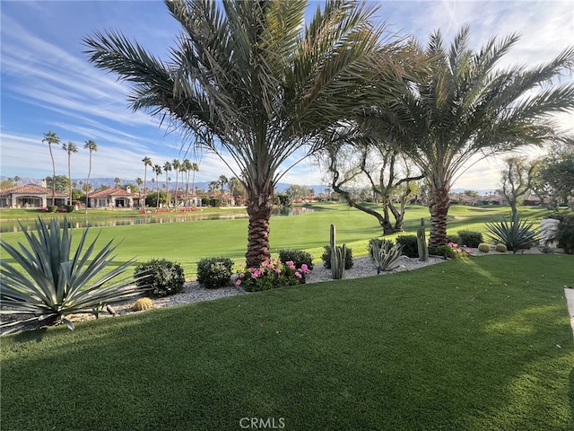 view of home's community featuring view of golf course and a lawn