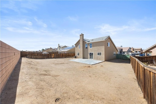 back of property with stucco siding, a residential view, a fenced backyard, and a patio area