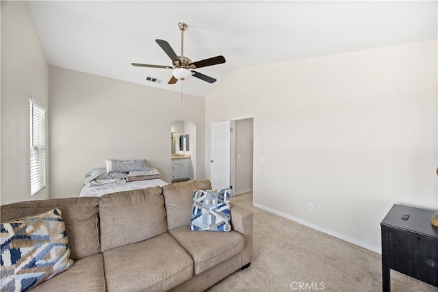 living area with visible vents, lofted ceiling, arched walkways, baseboards, and light colored carpet