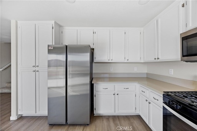 kitchen with white cabinetry, light countertops, and appliances with stainless steel finishes