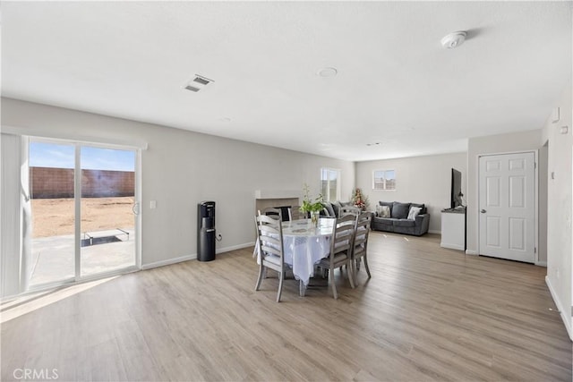 unfurnished dining area featuring light wood-style floors, visible vents, and baseboards