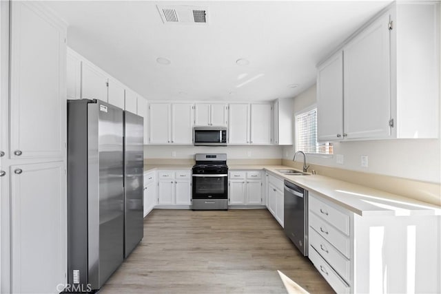 kitchen featuring white cabinetry, visible vents, appliances with stainless steel finishes, and a sink