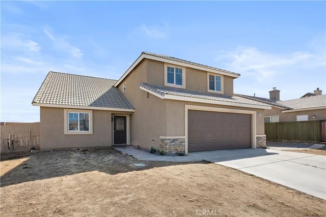 traditional-style house with concrete driveway, a tiled roof, fence, and stucco siding