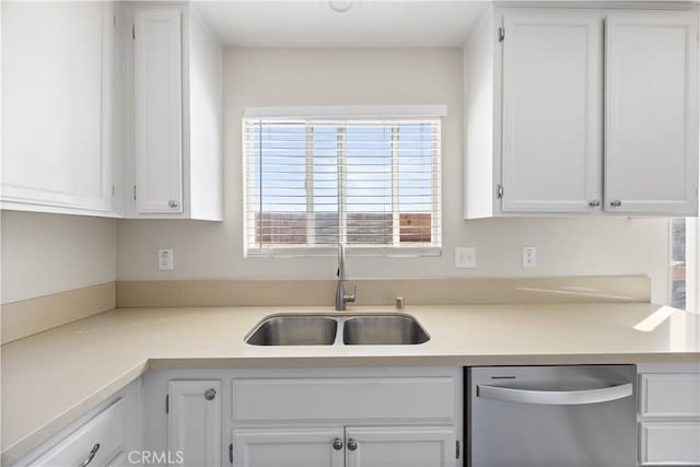 kitchen with stainless steel dishwasher, light countertops, white cabinets, and a sink