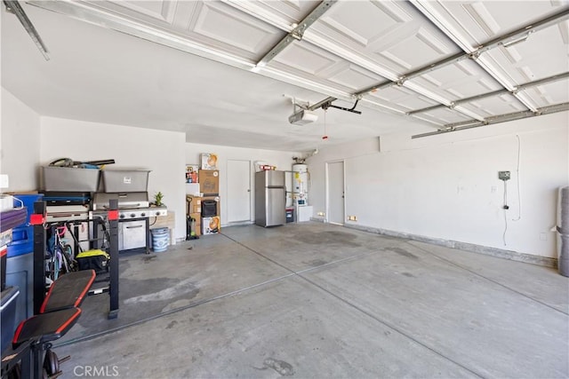 garage featuring a garage door opener, water heater, and freestanding refrigerator