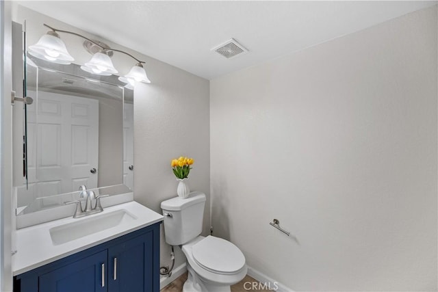 bathroom with visible vents, toilet, vanity, and baseboards