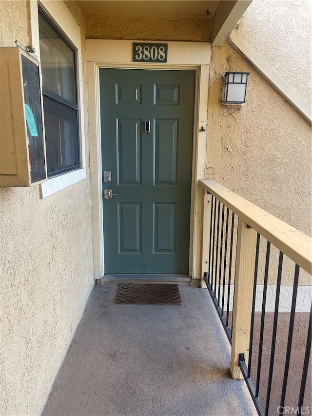 doorway to property featuring stucco siding