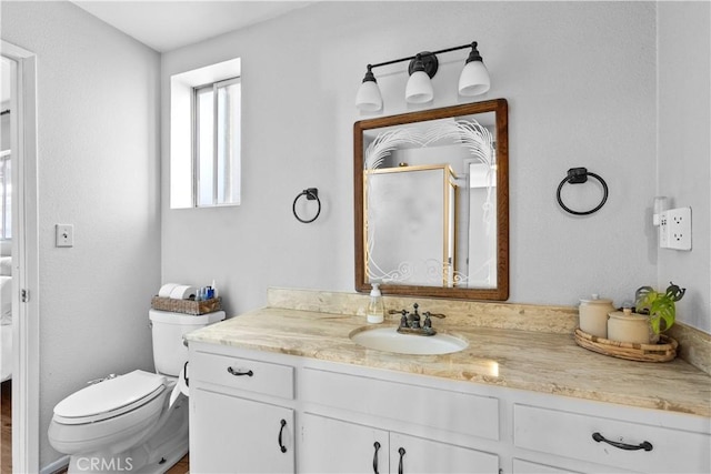 full bathroom with toilet, a stall shower, and vanity