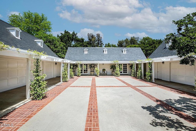 view of front of property featuring a garage, driveway, french doors, and stucco siding