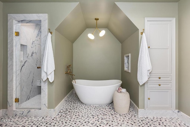 bathroom featuring a marble finish shower, lofted ceiling, a soaking tub, baseboards, and tile patterned floors